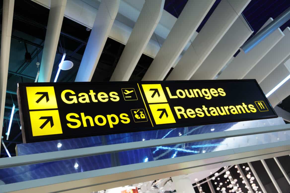 sign in airport directing to shops and restaurants