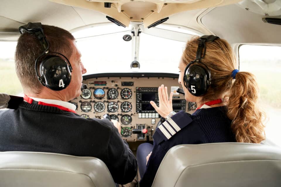 aircraft pilot training a student inside a cockpit